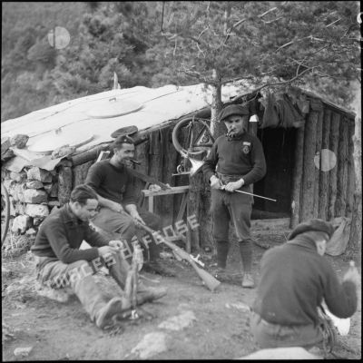 Des chasseurs du 9e BCA nettoient des fusils modèle 1907 au campement.
