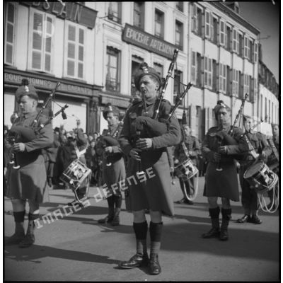 Un orchestre militaire britannique défile et joue dans une ville française.