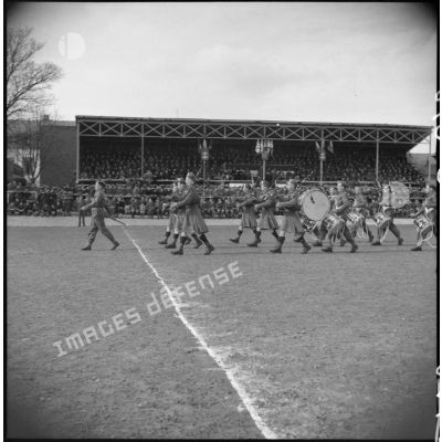 Un orchestre militaire de la British expeditionary force défile sur un terrain de rugby.