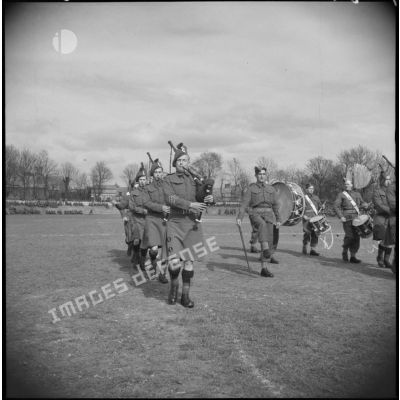 Un orchestre de la British expeditionary force défile sur un terrain de rugby.