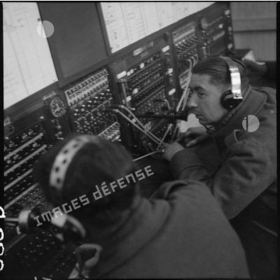 Deux soldats utilisent des appareils de transmissionss dans un central téléphonique.