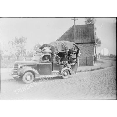 Des civils belges s'enfuient à bord d'un corbillard.