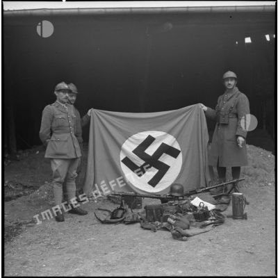 Des soldats de la 7e armée exposent leur "prise de guerre" sur du matériel allemand.
