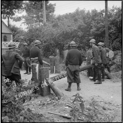 Des soldats de la 7e armée réparent une barrière.