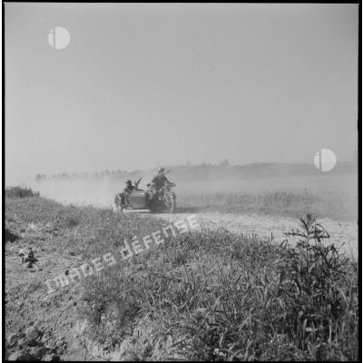 Des soldats de la 7e armée roule avec un side-car sur une route de campagne lors d'une manoeuvre.