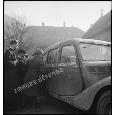 Soldat affecté au service de radiodiffusion travaillant à l'arrière de sa Renault Vivastella à 6 glaces.