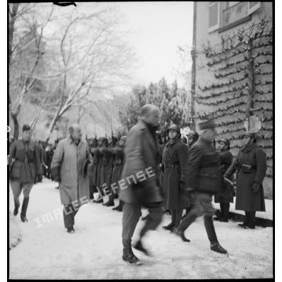 Le général de corps d'armée Corap et des représentants de l'autorité civile d'un village marchant dans une rue enneigée.