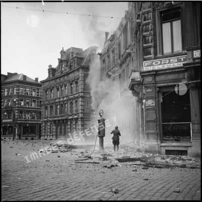 Bâtiments de la place Leopold de Namur en ruines et en feu après les bombradements allemands du 12 mai 1940.