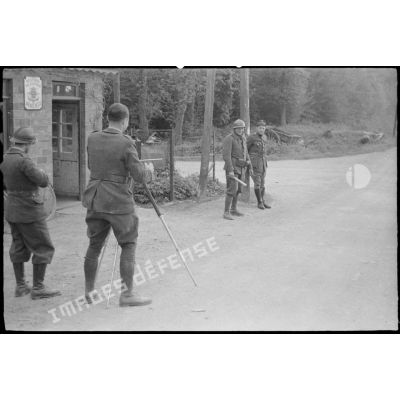 Un caméraman filme un douanier belge et un soldat français à un poste frontière.