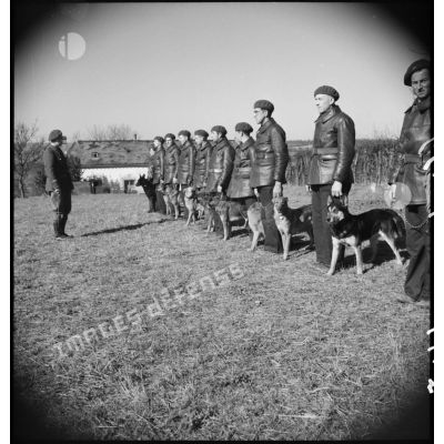 Passage en revue par un officier de soldats accomagnés de leurs chiens lors d'une formation cynophile.