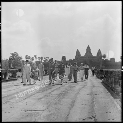 Le général Clark et son épouse accompagnés de la délégation avancent sur une grande allée d'Angkor Vat.