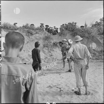 Au cours d'un échange de prisonniers des forces françaises et du Viêt-minh à Thanh Hoa, un prisonnier français est porté sur le dos d'un de ses camarades pour rejoindre le lieu d'embarquement.