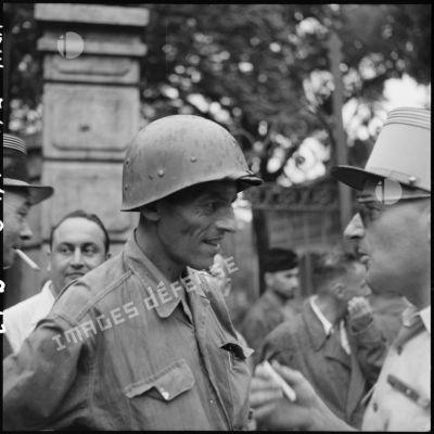 Le colonel Lalande, coiffé de son casque, à son arrivée à l'hôpital Lanessan après sa libération.