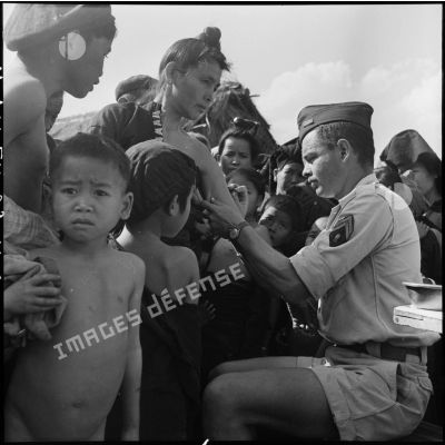 Vaccination d'une femme Thaï par un sergent du Service de santé dans un village de la cuvette de Diên Bien Phu.