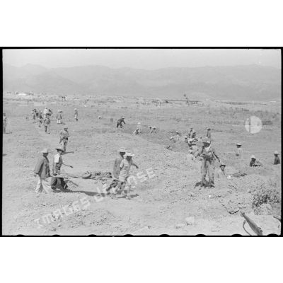 Des soldats creusent des tombes pour enterrer les morts sur le piton Isabelle du camp retranché de Diên Biên Phu.