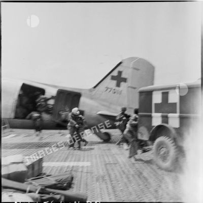 Embarquement de blessés à bord d'un avion Douglas C-47B skytrain (Dakota) au cours d'une évacuation sanitaire à Diên Biên Phu.