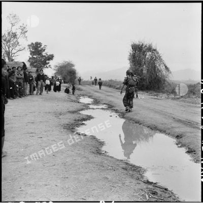 Des troupes parachutées près du camp de Diên Biên Phu traversent un village habité par des Thaï.