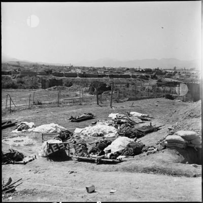 Les corps de soldats morts au combat, emmaillotés ou recouverts d'un tissu, gisent au sol près d'un point d'appui du camp retranché de Diên Biên Phu.
