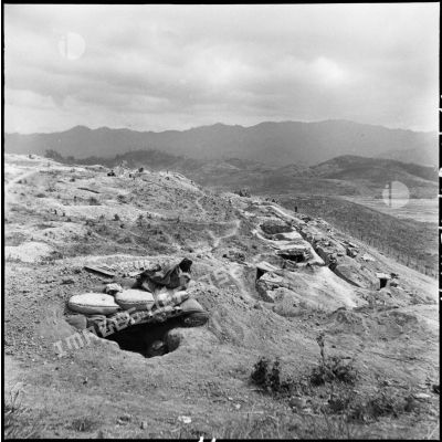Vue d'un centre de résistance de Diên Biên Phu avec abri fortifié et tranchées, surplombant la route provinciale 41.