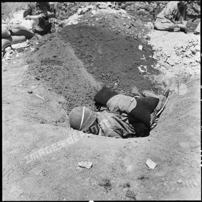 Un soldat blessé se protège dans un trou pendant que l'artillerie Viêt-minh pilonne le camp retranché de Diên Biên Phu.