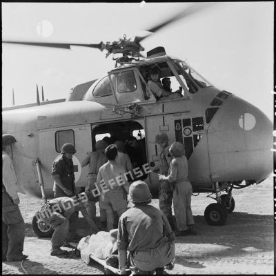 Embarquement de blessés dans un hélicoptère Sikorksy S55 au cours d'une évacuation sanitaire à Diên Biên Phu.