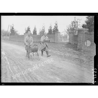Arvillers (Somme). Soldats regagnant la trnchée porteurs des journaux du jour et traînant une voiturette remplie de bidons de vin. [légende d'origine]