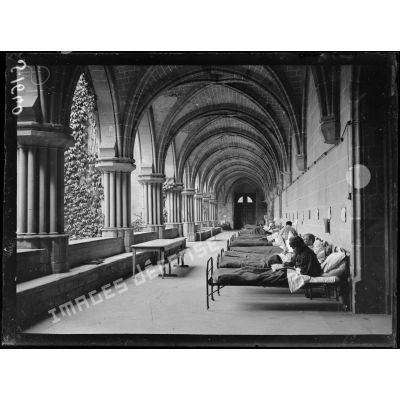 Asnières-sur-Oise. Ancienne abbaye de Royaumont. Hôpital écossais de 400 lits. Malades dans leur lit dans une galerie du cloître de l'abbaye. [légende d'origine]
