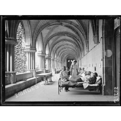 Asnières-sur-Oise. Ancienne abbaye de Royaumont. Hôpital écossais de 400 lits. Malades reposant dans leur lit dans une glaerie du cloître de l'abbaye. [légende d'origine]