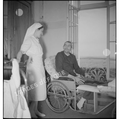 Une infirmière visite un officier blessé dans sa chambre à l'hôpital complémentaire d'armée du Mont des oiseaux.