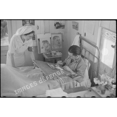 Une infirmière visite un blessé dans sa chambre à l'hôpital complémentaire d'armée du Mont des oiseaux.