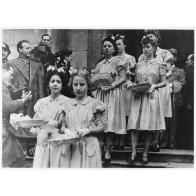 Les demoiselles d'honneur et les enfants qui tiennent la traîne de la mariée sortent de l'église lors du mariage du fils du général Charles Huntziger.