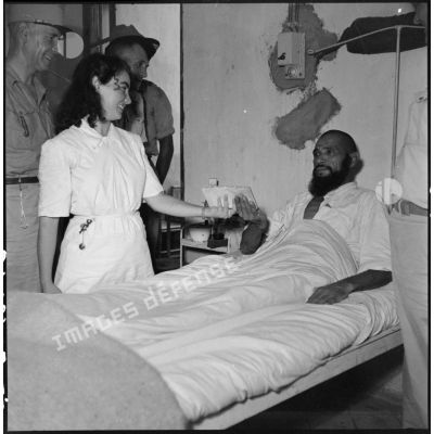 Le lieutenant-colonel Le Page, commandant le GTMEO (Groupement de tabors marocains en Extrême-Orient), rend visite à un goumier blessé et soigné à l' hôpital de Lang Son.