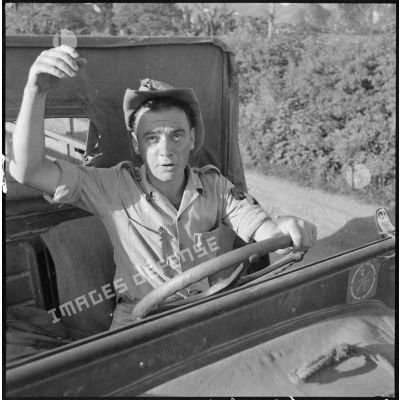 Un sergent de la Légion étrangère au volant d'une jeep sur une route du Tonkin.