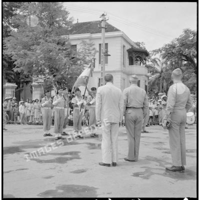 Les membres de la mission militaire américaine, M. Melby et le général Erskine, rendent les honneurs au drapeau et sa garde, au cours d'une cérémonie Haïphong.