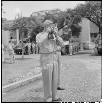Le général Erskine, membre de la mission militaire américaine, prend une photographie au cours d'une prise d'armes à Haïphong.