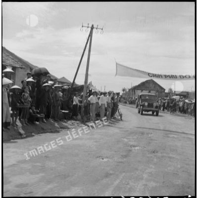 Passage dans les rues de Dap Cau du convoi transportant les membres de la mission militaire américaine Melby-Erskine.