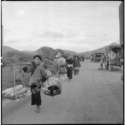 Montagnards se rendant à Ky Lua un jour de grand marché, sous la surveillance de militaires postés en bord de route.