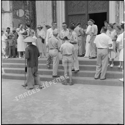 Après la messe, militaires et civils  conversent sur le parvis de la cathédrale d'Hanoï.