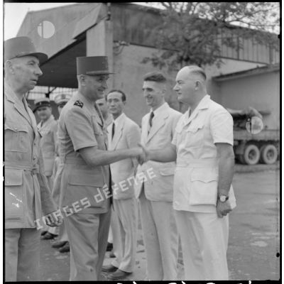 Le général Carpentier échange une poignée de main avec M. Lamdière, conseiller régional, sur l'aérodrome de Bach Maï.