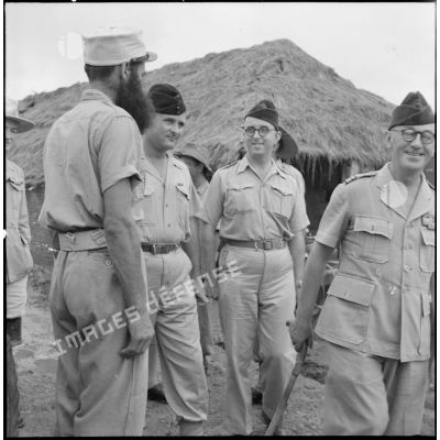 Le colonel Gambiez, commandant la zone delta-nord, inspecte le détachement d'honneur et le matériel du Génie ayant contribué à la construction du pont de Trinh Duc Ha.