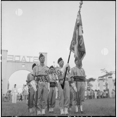 La garde au drapeau du bataillon de marche indochinois (BMI) avec le drapeau du 1er régiment de tirailleurs tonkinois (RTT) qui lui a été confié, au cours d'une cérémonie sur le stade d'Haïduong.