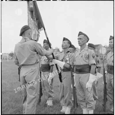 Remise du drapeau de l'ancien 1er RTT par le capitaine Bigeard, commandant le BMI (bataillon de marche indochinois), à sa nouvelle garde au cours d'une cérémonie sur le stade d'Haïduong.