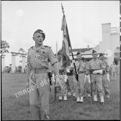 Le capitaine Bigeard devant le nouveau drapeau du BMI (bataillon de marche indochinois) et sa garde lors d'une cérémonie sur le stade d'Haïduong.