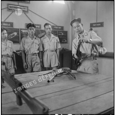 Elèves de l'école des cadres d'Hanoï lors d'une séance de montage et démontage d'un fusil-mitrailleur Bren.