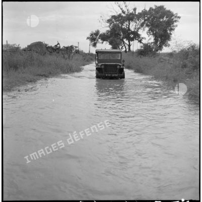 Passage d'une jeep sur un chemin inondé entre Hanoï et Luc Nam.