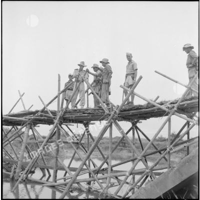 Suite à la destruction du pont, le génie construit un pont de bambous pour rétablir la communication sur la RC 3 (route coloniale n°3).