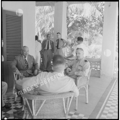 Le général Carpentier, commandant en chef en Indochine, s'entretient autour d'une table avec M. Deo Van Long, président de la fédération Thaï et M. Tersakissof, chef de province, au cours d'une visite à Laï Chau.