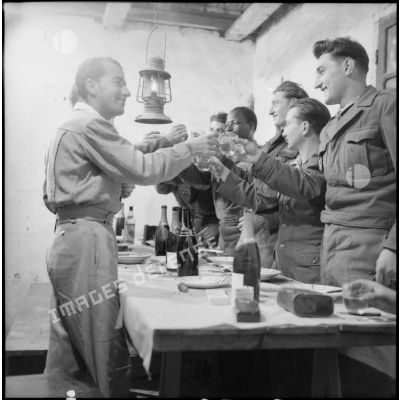 Des soldats d'un poste du delta tonkinois portent un toast pendant leur repas de noël.