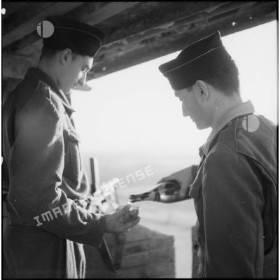 Un soldat sert un verre de champagne à une sentinelle surveillant un poste du delta du Tonkin.