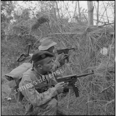 Des parachutistes du 10e bataillon parachutiste de chasseurs à pied (10e BPCP) armés de pistolet-mitrailleurs MAT 49 se préparent à donner l'assaut sur le village de Moi Phat.